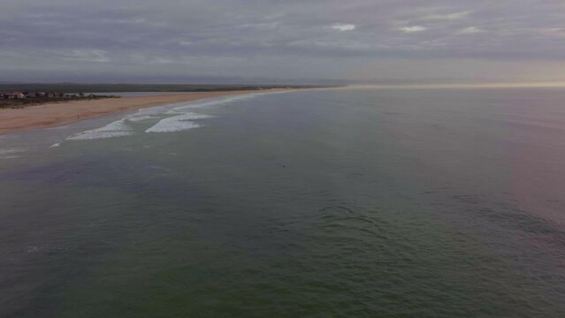 Africa drone aerial cinematic dolphins pod swimming blow holes sunrise sunset early morning ocean surf waves JBAY Jefferys Bay Indian Ocean deep aqua blue water cloudy golden backward movement