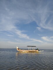 Bali Island, 05 May 2022 : Beatiful Landscape Wooden boat in the sea with blue sky and white clouds...