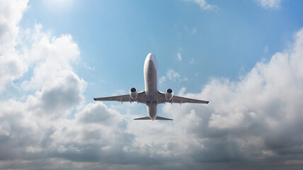 Fototapeta na wymiar White passenger airplane flying in the sky amazing clouds in the background - Travel by air transport