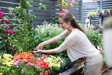 nice european girl looking at flowers in shop