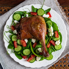 Roast duck salad with pea tendrils, cucumber, chopped tomatoes, and feta cheese.