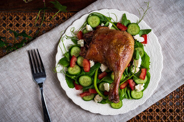 Roast duck salad with pea tendrils, cucumber, chopped tomatoes, and feta cheese.