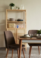 The interior of a large U-shaped kitchen with a wooden front and a large island. Stylish, cozy kitchen with appliances and plants with sun rays. View from the ceiling to kitche