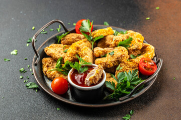 Chicken nuggets with ketchup sauce on a dark background, place for text, top view