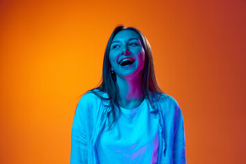 Portrait of beautiful young woman in casual clothes cheerfully laughing, smiling against gradient...