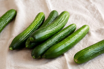 Organic Mini Baby Cucumbers on a white wooden background, low angle view.
