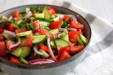 Homemade Mediterranean Cucumber Tomato Salad in a Bowl, side view. Close-up.