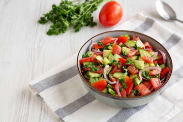 Homemade Mediterranean Cucumber Tomato Salad in a Bowl, side view. Space for text.