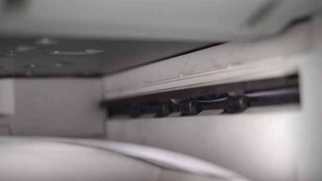 Closeup of aser jet printer printing A4 paper pages in a storehouse or a business office