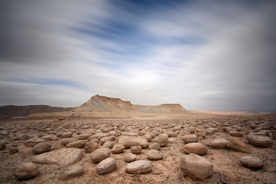 lime stone field with a mouton in the background and a moving clouds 