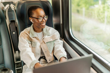Young woman working on laptop computer on the train.