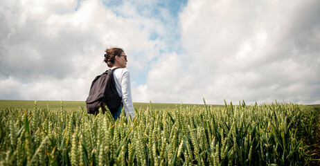Woman walking through wheat field, getting away from it all.