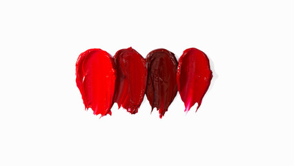 Pattern smears and textures of lipsticks or acrylic paints isolated on white background. Cream makeup texture. Bright red color cosmetic product brush stroke swipe sample. Top view