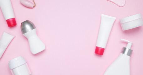 Cosmetic beauty products on pink background. Bottles and tubes with branding mock up. Skin care and beauty concept. Top view, flat lay, copy space, banner