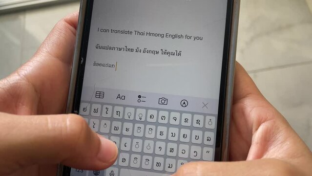 Woman hand typing on phone keyboard English, Thai and Hmong language. Point of view shot