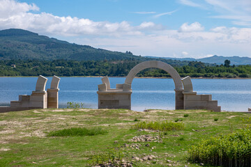 Roman ruins with lake. Aquis Querquennis archaeological site, arched stone door. Baños de Bande,...