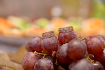 wedding rings on a red grapes 
