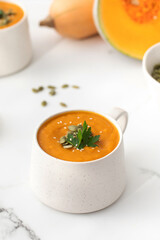 A mug of warm pumpkin soup. The concept of the autumn menu. Autumn recipes.