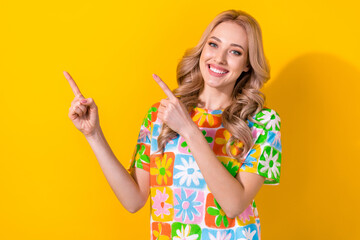 Photo of attractive lady direct fingers empty space advise travel agency wear floral shirt isolated yellow color background