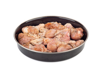 Ready-to-bake chicken drumsticks in a round metal mold over a white background.