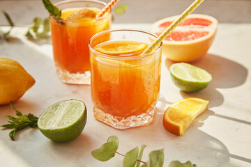 Summer orange cocktails with fresh citrus fruits. Hard seltzer, lemonade, refreshing drinks, low alcohol mocktails, summer party concept. Shadow and sunlight