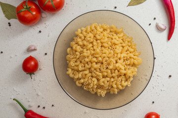 Italian pasta on table with tomatoes, pepper and different species