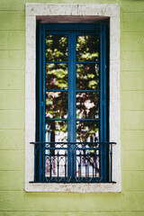 Fototapeta na wymiar Façade de maison avec peinture verte et grande fenêtre noire
