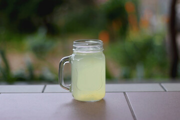 Glass of lemonade served in the garden. Selective focus.