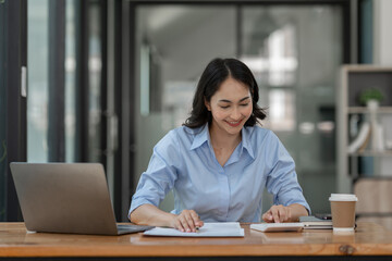 Confident businesswoman working using calculator to calculate profit financial investment document...