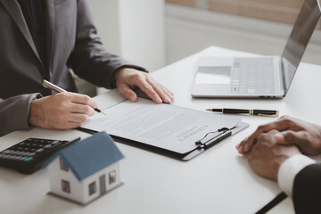 Real estate agents explain models of housing estates in projects to elaborate to clients, explaining and presenting information about homes and purchasing loans. Real estate trading concept.