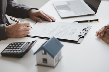Real estate agents explain models of housing estates in projects to elaborate to clients, explaining and presenting information about homes and purchasing loans. Real estate trading concept.