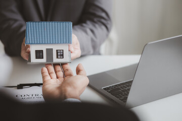 Real estate agents explain models of housing estates in projects to elaborate to clients,...