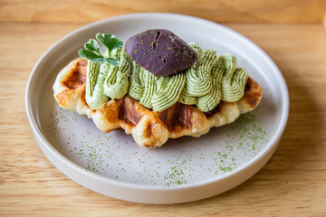 Green tea waffles in a white plate on a Japanese traditional wooden tray.