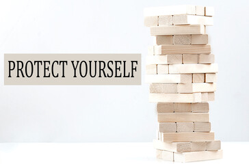 PROTECT YOURSELF text with wooden block stack on white background , business concept