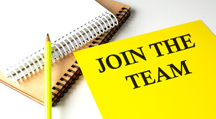 JOIN OUR TEAM text written on a yellow paper with notebook