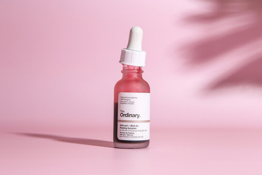 Warszaw, Poland - May, 2023: The Ordinary skincare brand by Deciem. Bottles with red peeling and solutions. Closeup of The Ordinary Peeling on pink background
