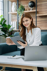 Female businessmen sitting at the desk, looking to camera.