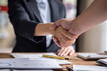 Obraz premium Business handshake for teamwork of business merger and acquisition,successful negotiate,hand shake,two businessman shake hand with partner to celebration partnership and business deal concept 