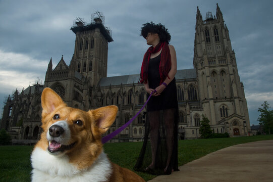 Young woman and a dog in front of the Washington National Cathedral in Washington, DC, USA; Washington, District of Columbia, United States of America