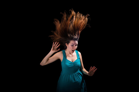 Young woman's hair flies dramatically up into the darkness; Lincoln, Nebraska, United States of America