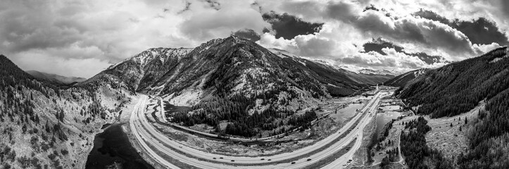 Highway Interstate 70 curves through a mountainous landscape under a cloudy sky in Colorado, USA; United States of America