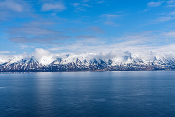 The beautiful snow-capped mountains of the North Fjords in North Iceland with a bright, blue sky above them; North Iceland, Iceland