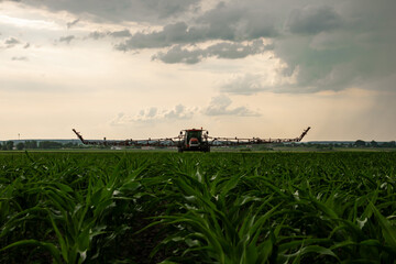 Red sprayer working in field of course 