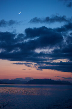 Sunset afterglow with a sickle moon over the Inside Passage, near Sitka, Alaska, USA; Alaska, United States of America