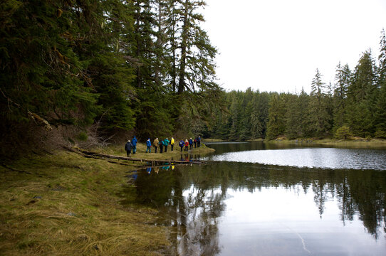 Hikers near an old growth forest along Lake Eva River, Hanus Bay, Inside Passage, Alaska, USA; Alaska, United States of America