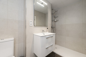 Fototapeta na wymiar Small, modern bathroom with walk-in shower, frameless mirror on the wall