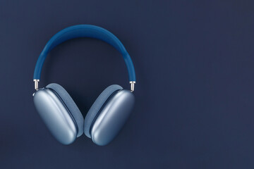 Fototapeta na wymiar Wireless blue headphones on a dark blue background. Copy space