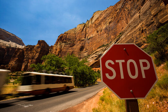 Propane powered shuttle bus passes a stop sign in Zion National Park; Utah, United States of America