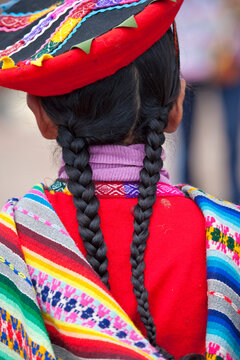 Rear view of a young girl with braids in traditional Peruvian clothing; Sacred Valley, Peru