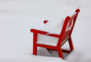 Red outdoor chair covered in deep snow; Surrey, British Columbia, Canada